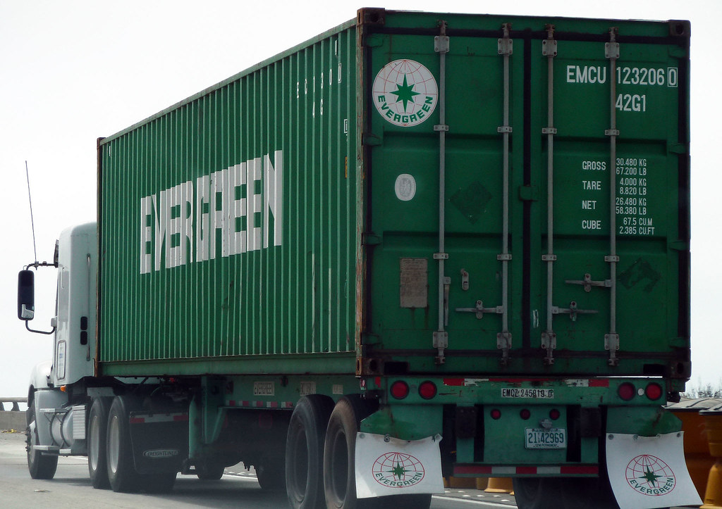 Tractor-trailer moving a shipping container.